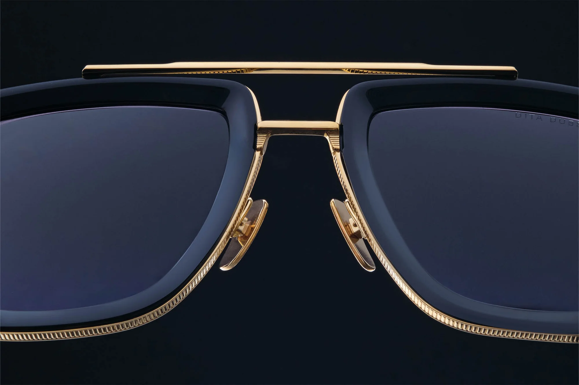 Dark sculptural sunglasses shown in close detail
