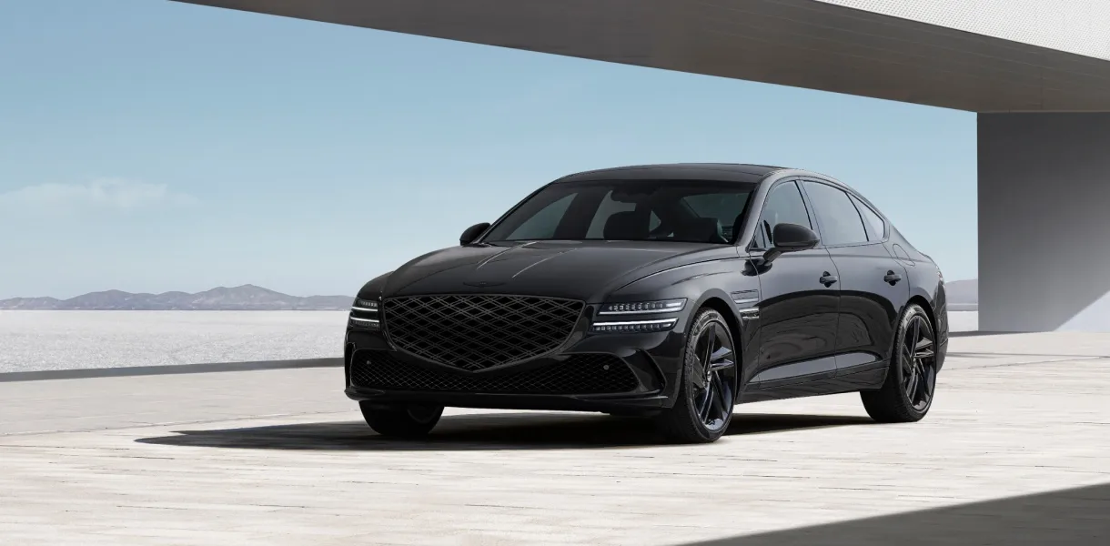 Black Genesis G80 luxury sedan driving on a dark road