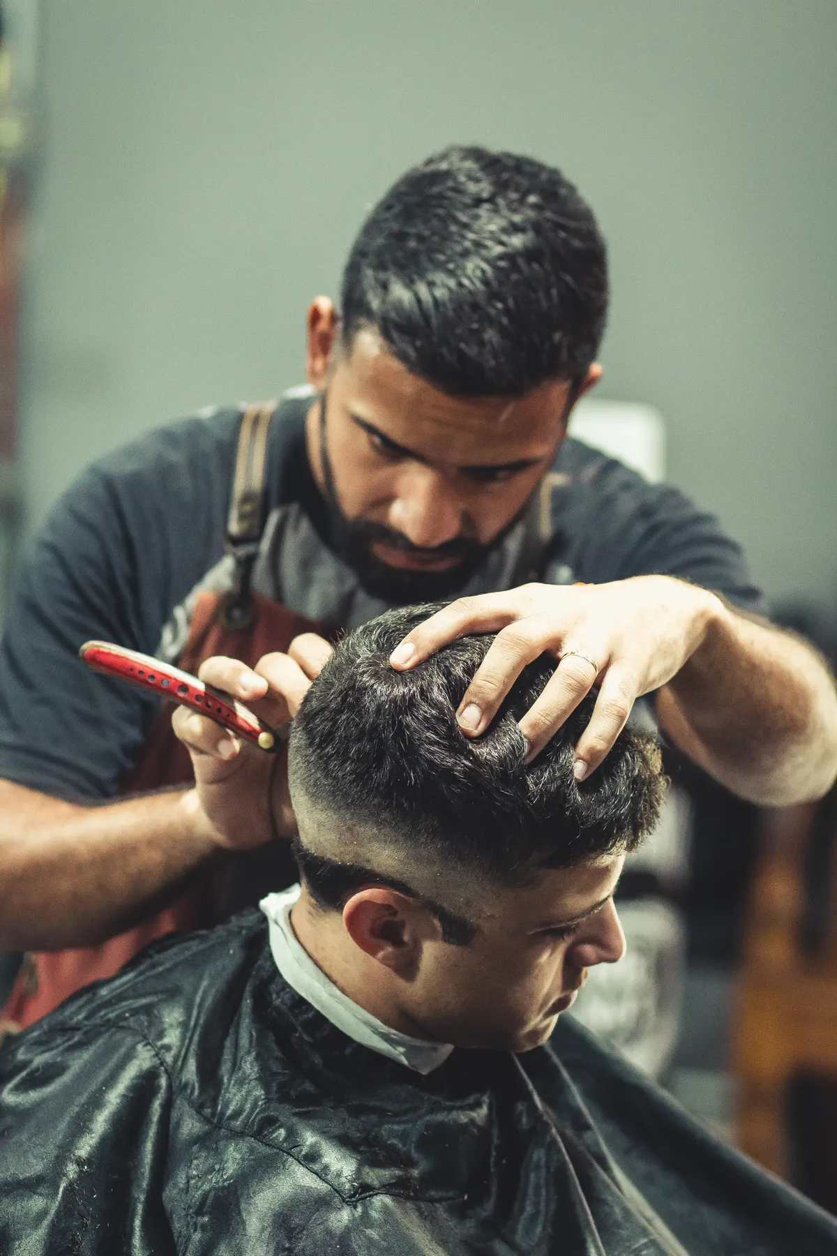 Barber shaping a neat fade with a razor