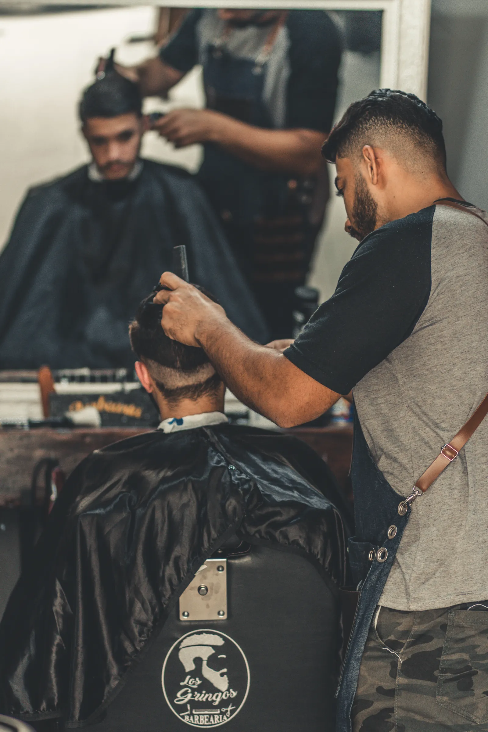 Barber giving a precise haircut in a busy shop