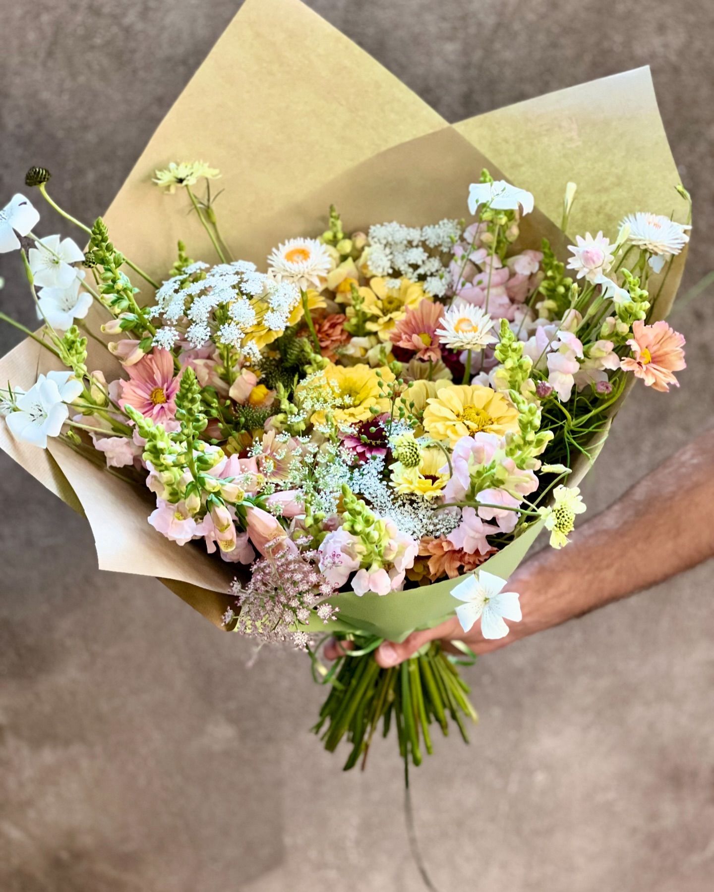 Loose pastel seasonal bouquet wrapped in kraft paper
